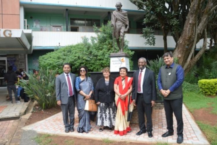 The team poses on the Mahatma Gandhi statue